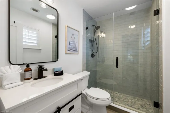 Full bathroom with vanity and a shower stall