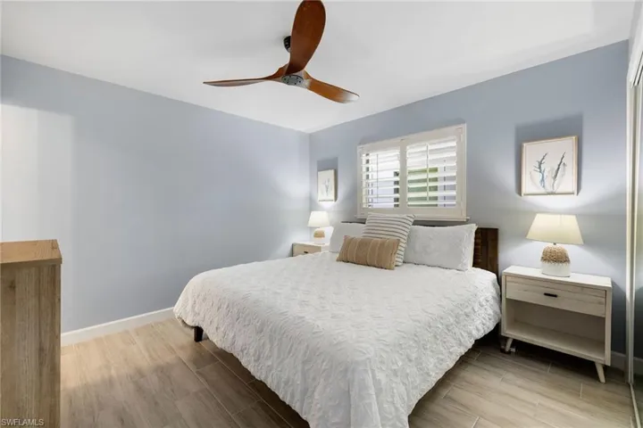 Bedroom with wood tiled floors and a ceiling fan
