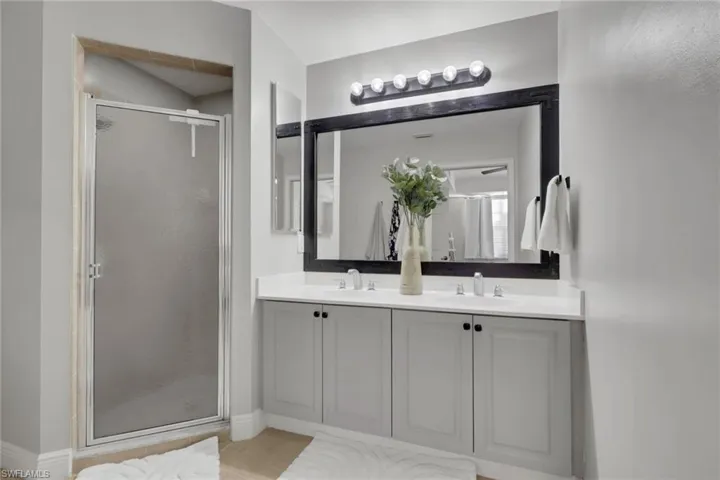 Bathroom featuring a stall shower and double vanity