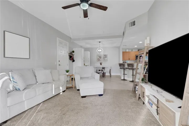 Living room featuring a ceiling fan, light colored carpet, and recessed lighting