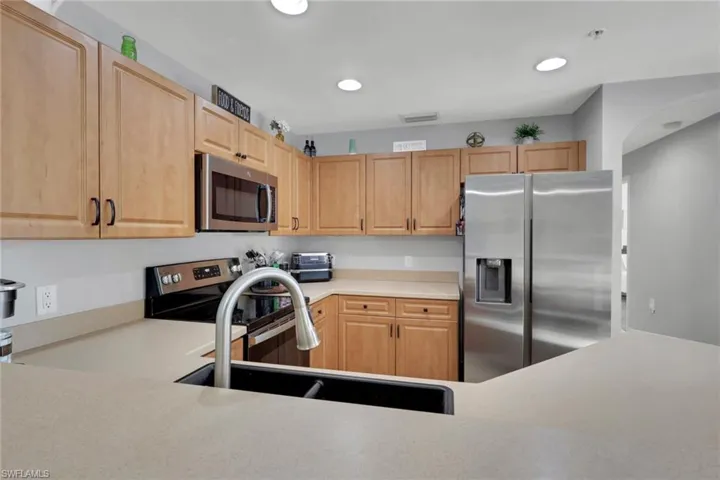 Kitchen featuring stainless steel appliances, light countertops, and light wood finish cabinetry