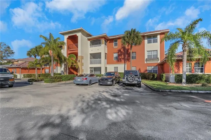 View of apartment building / complex featuring uncovered parking