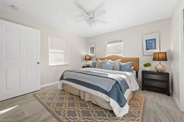 Bedroom featuring a ceiling fan, multiple windows, and light wood finished floors