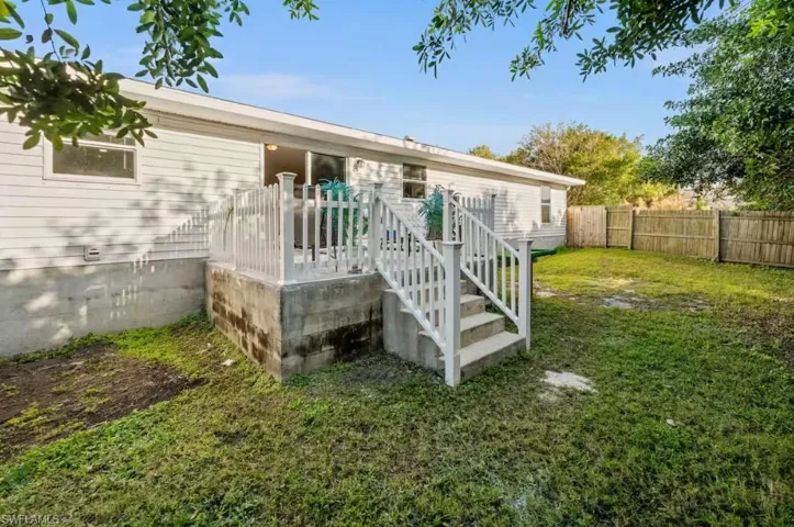 Rear view of property featuring stairs and a deck