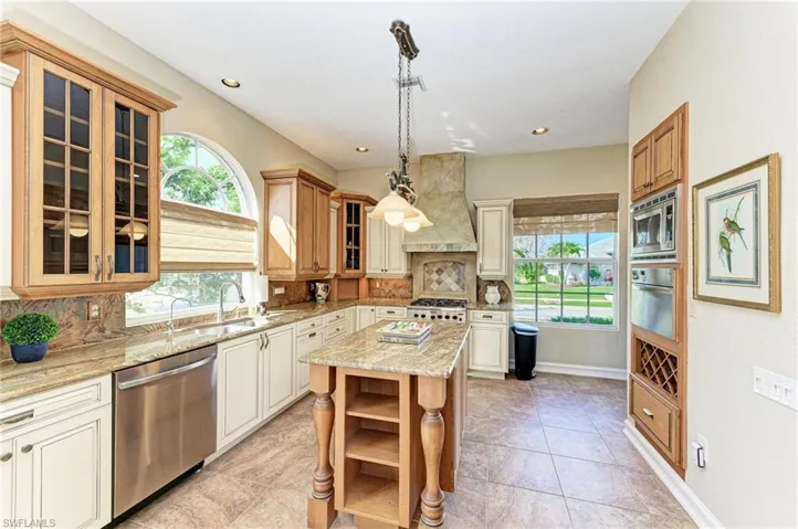 Kitchen with appliances with stainless steel finishes, tasteful backsplash, a kitchen island, and premium range hood