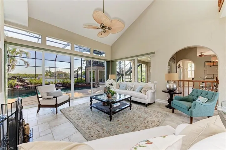 Living room featuring ceiling fan, a healthy amount of sunlight, and high vaulted ceiling