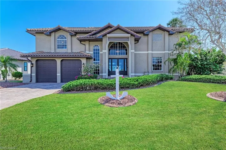 View of front of home featuring a front yard, french doors, and a garage