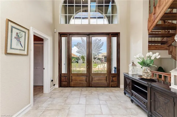 Foyer featuring plenty of natural light, a high ceiling, and french doors