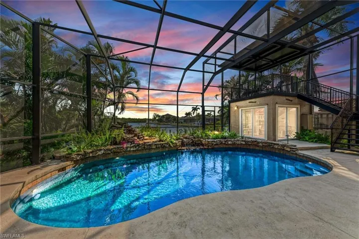Pool at dusk featuring a patio and a lanai