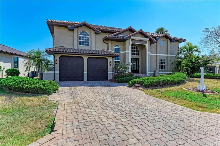 View of front of property featuring a garage and a front lawn