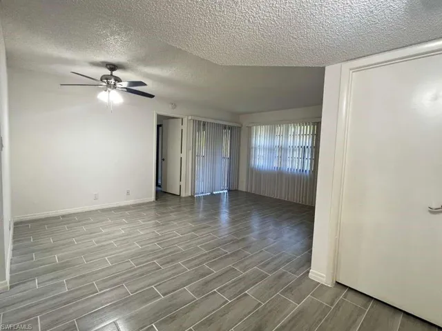 Unfurnished bedroom with a textured ceiling, wood tiled floors, and ceiling fan