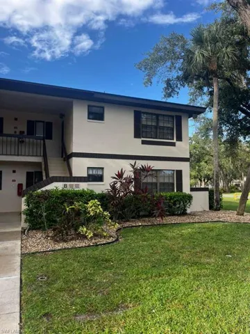 View of front facade featuring a front lawn and stucco siding