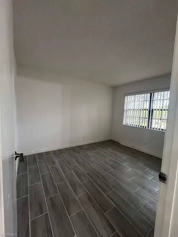 Unfurnished room featuring wood finish floors and a textured ceiling
