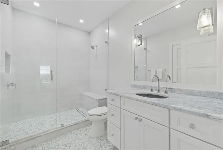 Full bath with a stall shower, vanity, light tile patterned floors, and recessed lighting