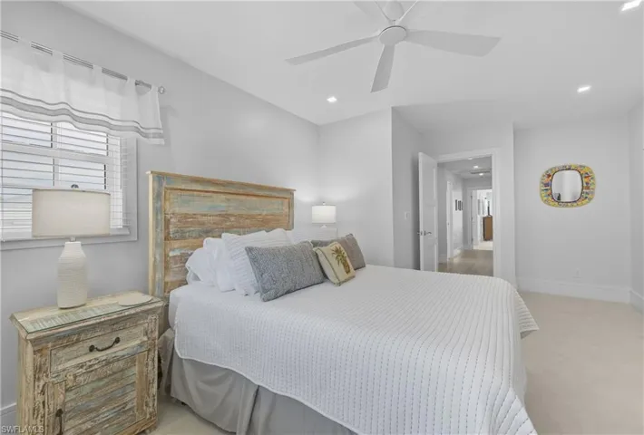 Bedroom with light colored carpet, ceiling fan, and recessed lighting