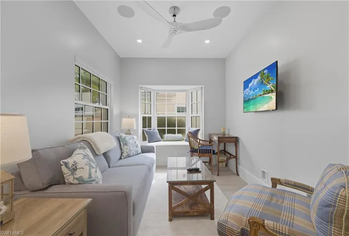 Living area with ceiling fan, wood finished floors, and recessed lighting