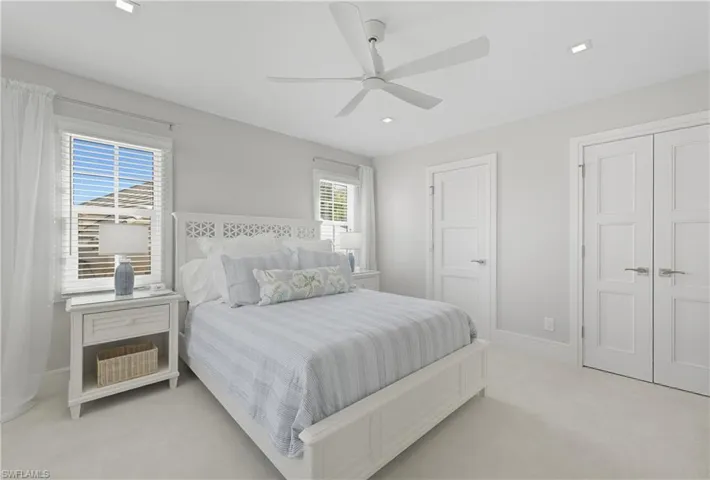 Bedroom featuring light colored carpet, ceiling fan, a closet, and recessed lighting