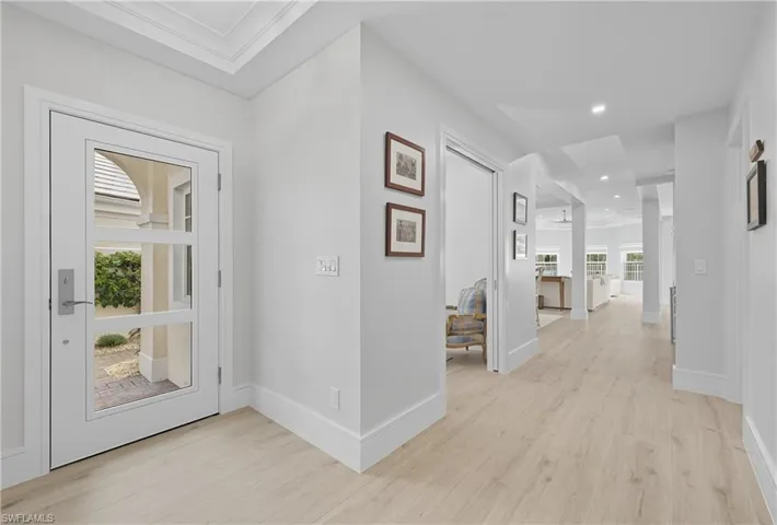 Hallway with light wood finished floors and recessed lighting