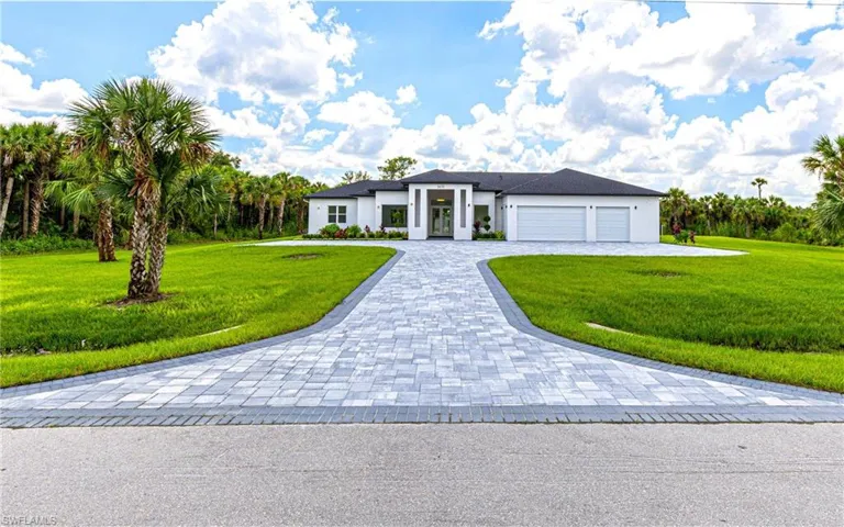 View of front of house featuring a front lawn, an attached garage, decorative driveway, and stucco siding