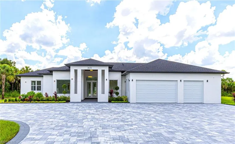 Prairie-style house with french doors, an attached garage, decorative driveway, and stucco siding