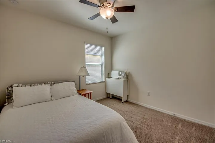 Carpeted bedroom featuring ceiling fan