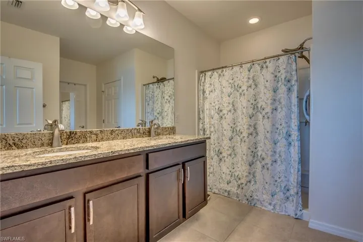 Bathroom featuring tile floors and double sink vanity