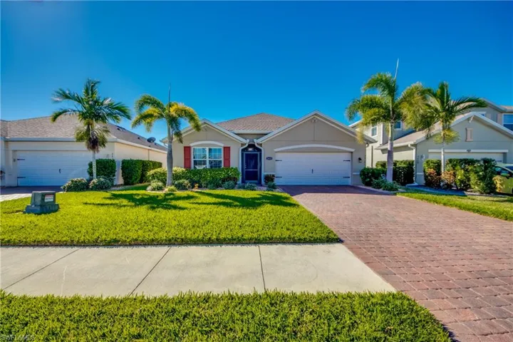Ranch-style house with a garage and a front lawn