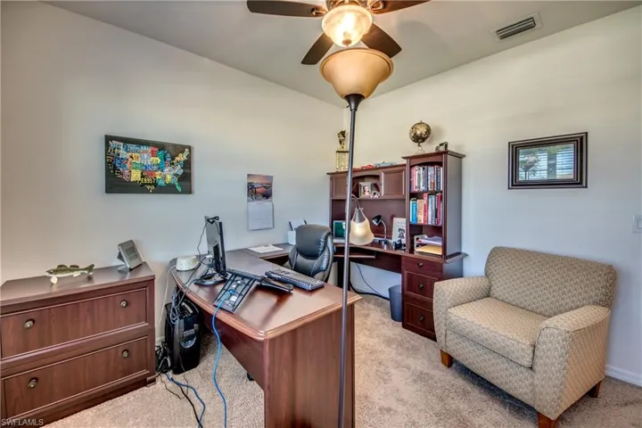 Carpeted office space featuring ceiling fan