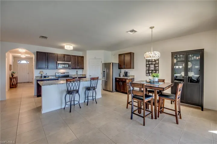 Dining area featuring a chandelier, sink, and light tile flooring