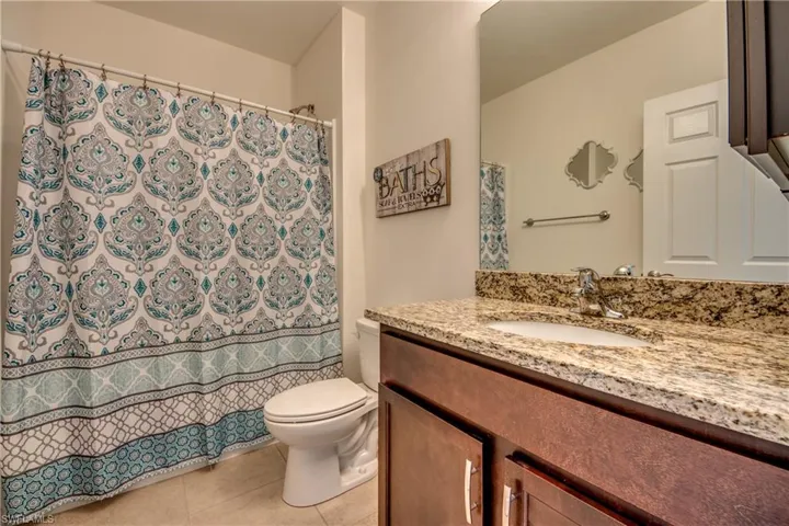 Bathroom featuring tile floors, oversized vanity, and toilet