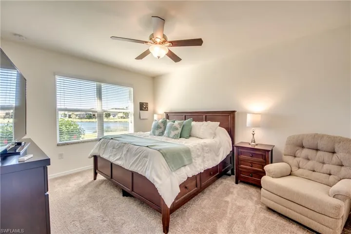 Carpeted bedroom featuring ceiling fan