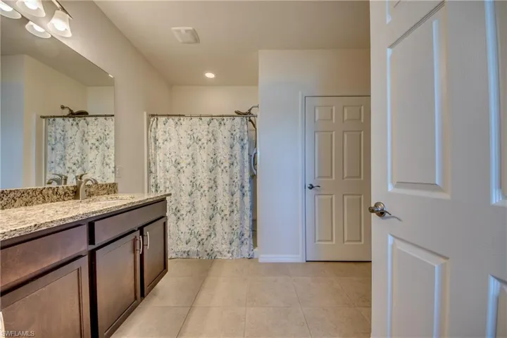 Bathroom with tile floors and vanity with extensive cabinet space