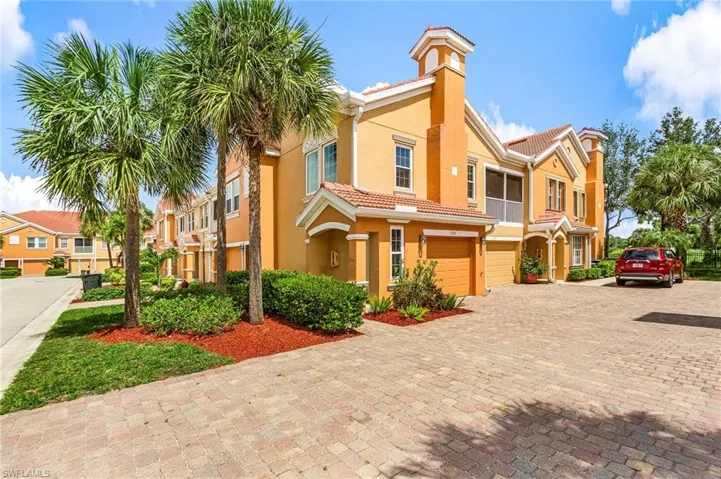 Mediterranean / spanish home with decorative driveway, a tiled roof, stucco siding, an attached garage, and a chimney