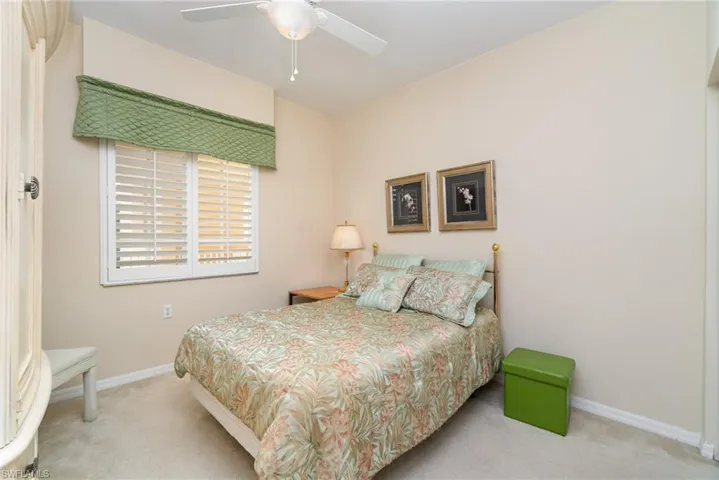 Guest Bedroom featuring Armoire with TV, carpet, closet and a ceiling fan.