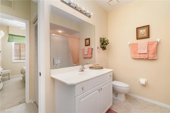 Guest Bathroom with vanity, tub and shower combo, large linen closet and light tile patterned flooring.