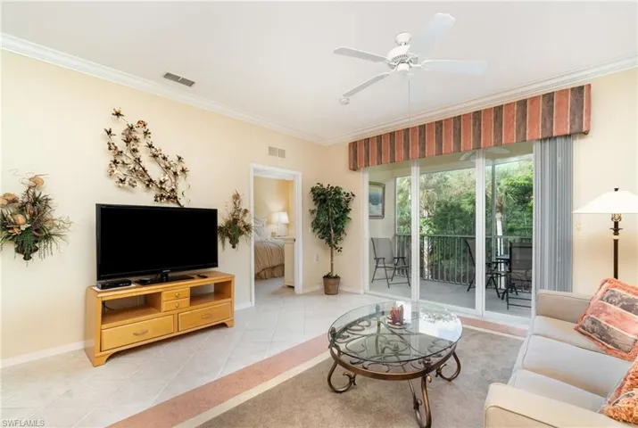 Living area featuring crown molding and ceiling fan with access to the lanai and primary bedroom.