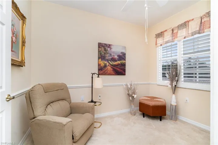 Den featuring Armoire with TV,  carpet and ceiling fan.