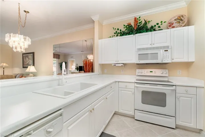 Kitchen featuring white appliances, tile and a pantry closet.