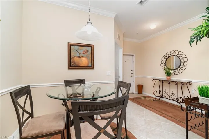 Dinette with tiled flooring, crown molding and chair rail. Open to the kitchen and entry hall.