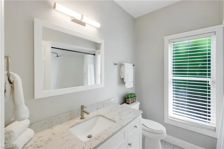 guest bath with Quartz counters and Tub/shower combo + Linen closet