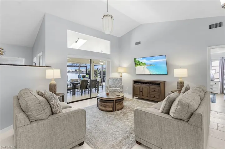 Living area with high vaulted ceiling and baseboards