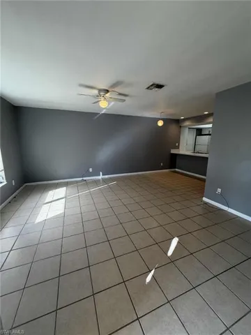 Unfurnished living room with light tile patterned floors and ceiling fan