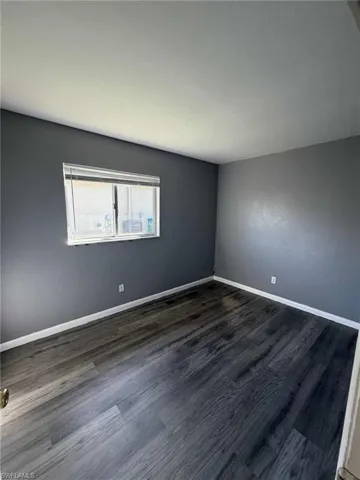 Spare room with dark wood finished floors
