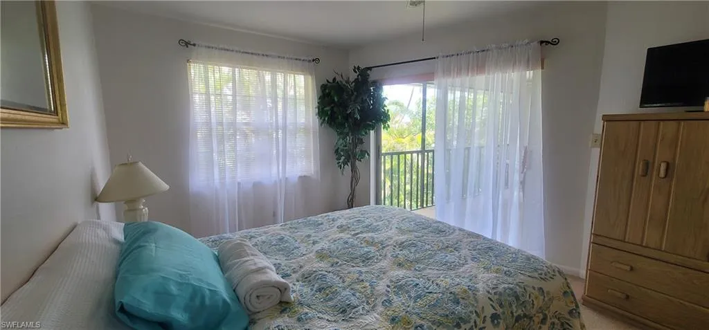 Carpeted bedroom with access to exterior and baseboards