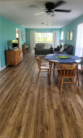 Dining area with dark wood-style flooring and ceiling fan