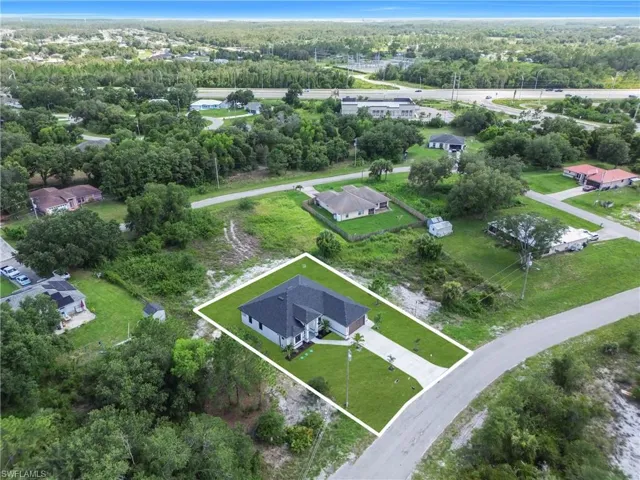 Aerial view of property and surrounding area featuring property boundaries highlighted and a tree filled landscape
