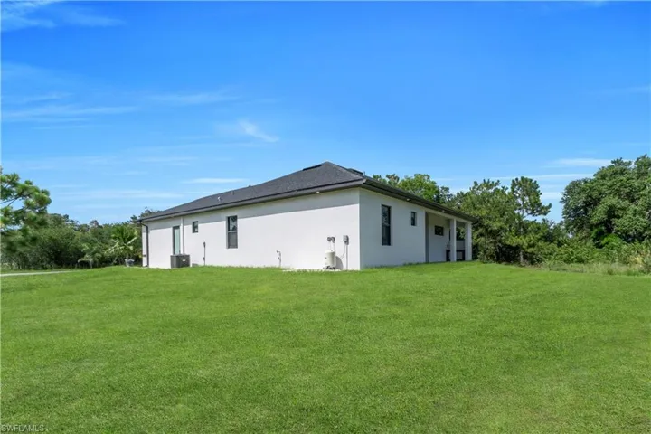 View of side of property with stucco siding and a lawn