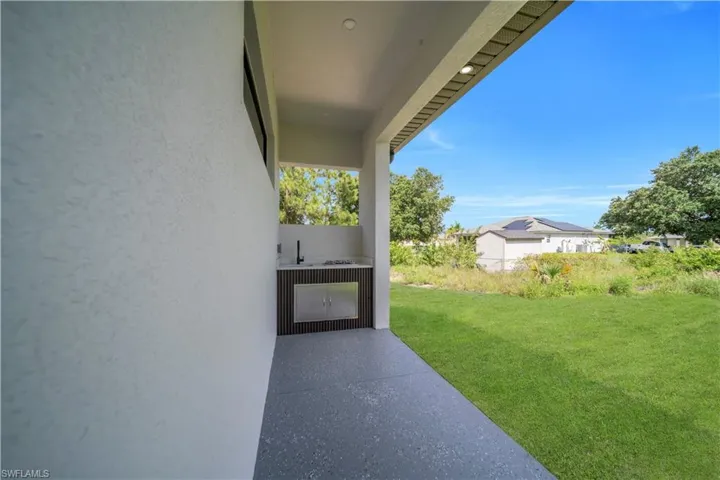 View of grassy yard featuring exterior kitchen