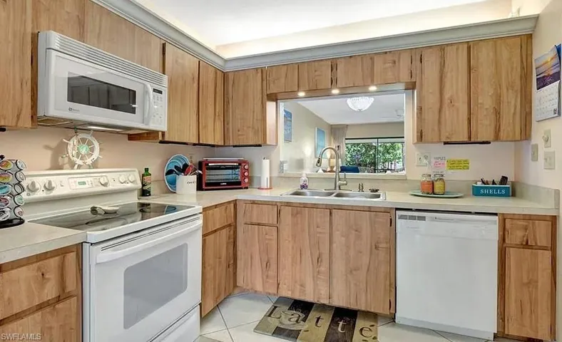 Kitchen with white appliances, light countertops, and light tile patterned floors