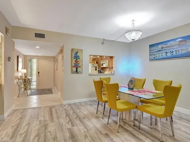 Dining space with light wood-style floors and suspended lighting